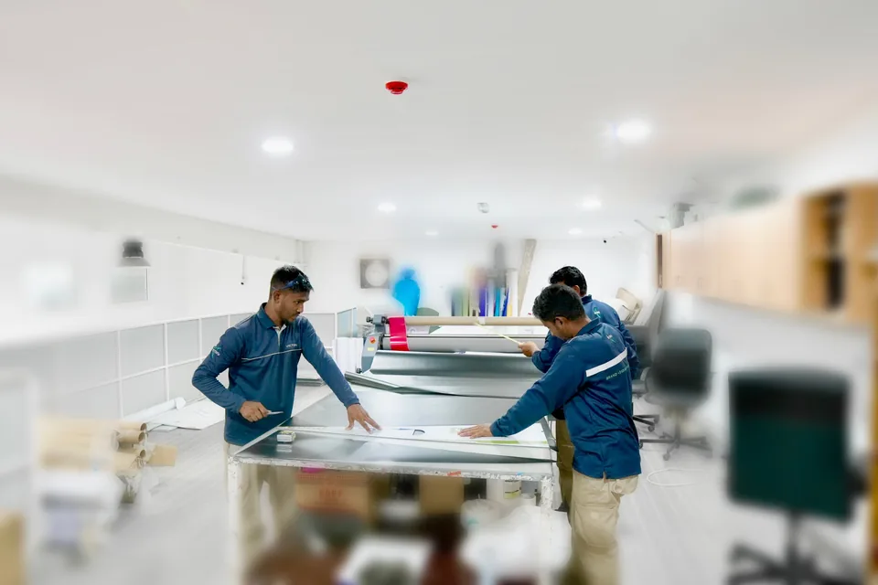 Victory team cutting large-format vinyl graphics on the production table